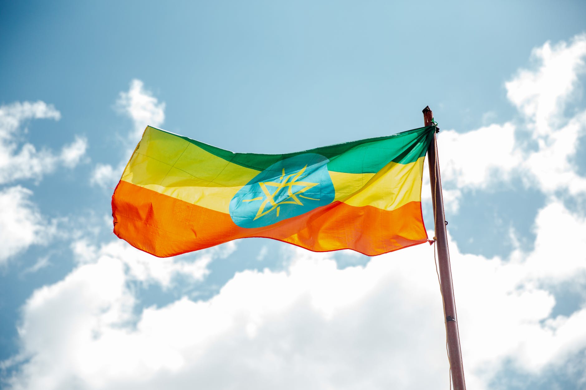 national colorful flag of ethiopia under cloudy sky